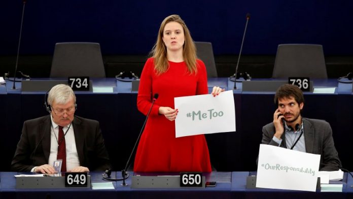 European Parliament member Terry Reintke holds a placard with the hashtag