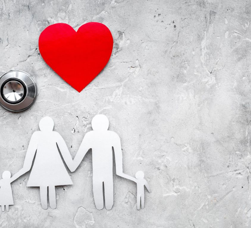 Take out health insurance for family. Stethoscope, paper heart and silhouette of family on grey stone background top view copyspace